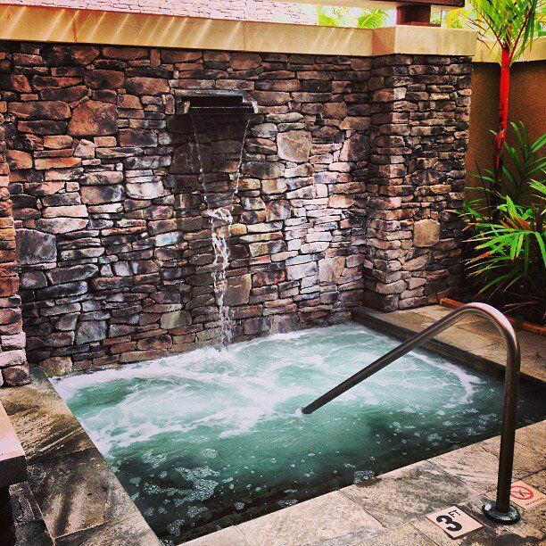 A cascading waterfall into the hot tub of swirling sea salt water